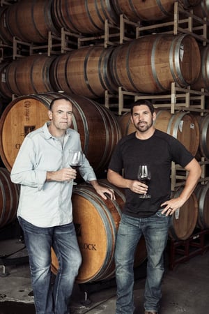 Image of Charlie Palmer next to wine barrels.