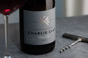 A close up image of wine label, opener and glass.
