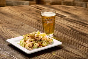 Image of a plate with garlic lemon shrimp skewers and a drink on the side.