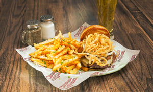 A plate with a Fun-ion Burger with French fries and a drink.