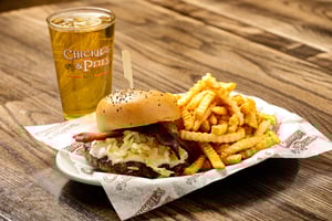 Image of plate with a French onion burger, fries and a drink.
