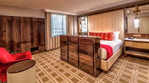 Photo of bedroom with TV stand lowered in the Ambassador Suite at Grand Sierra Resort in Reno, Nevada.